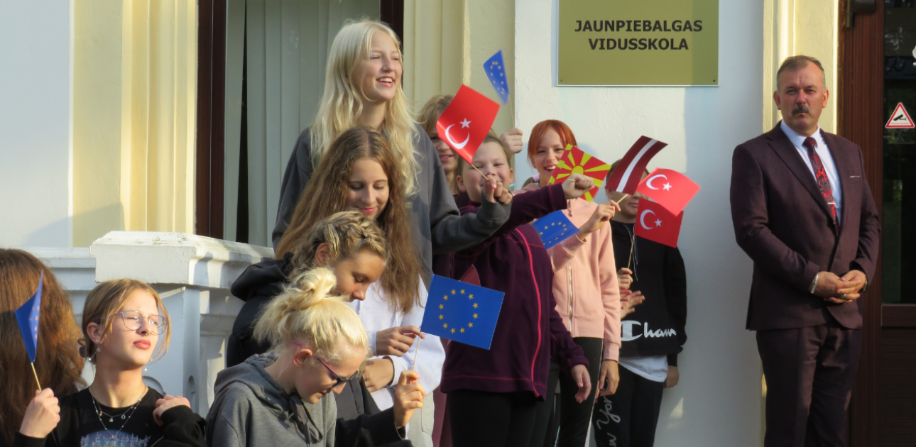 Bērni stāv trpēm ar dažādu valstu karodziņiem