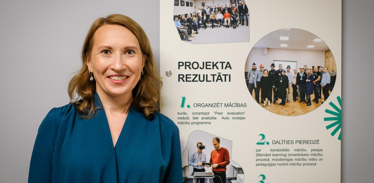 Sieviete pozē pie projekta plakāta