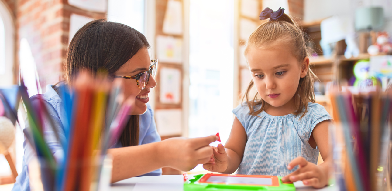 Pirmsskolas vecuma meitenīte mācās kopā ar pedagogu